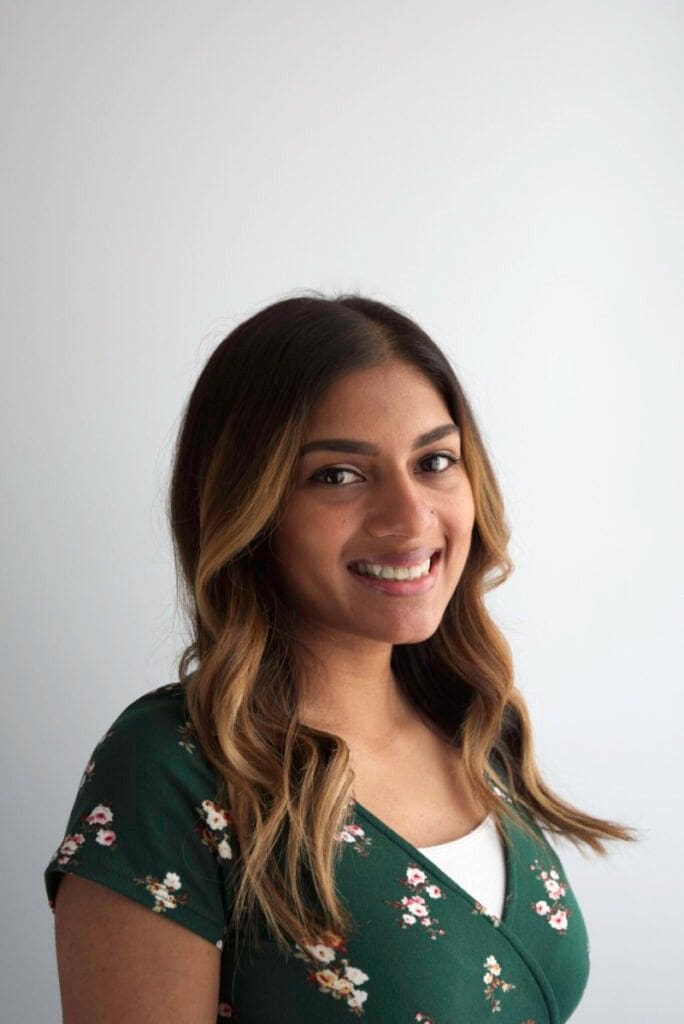 Smiling woman in floral dress.