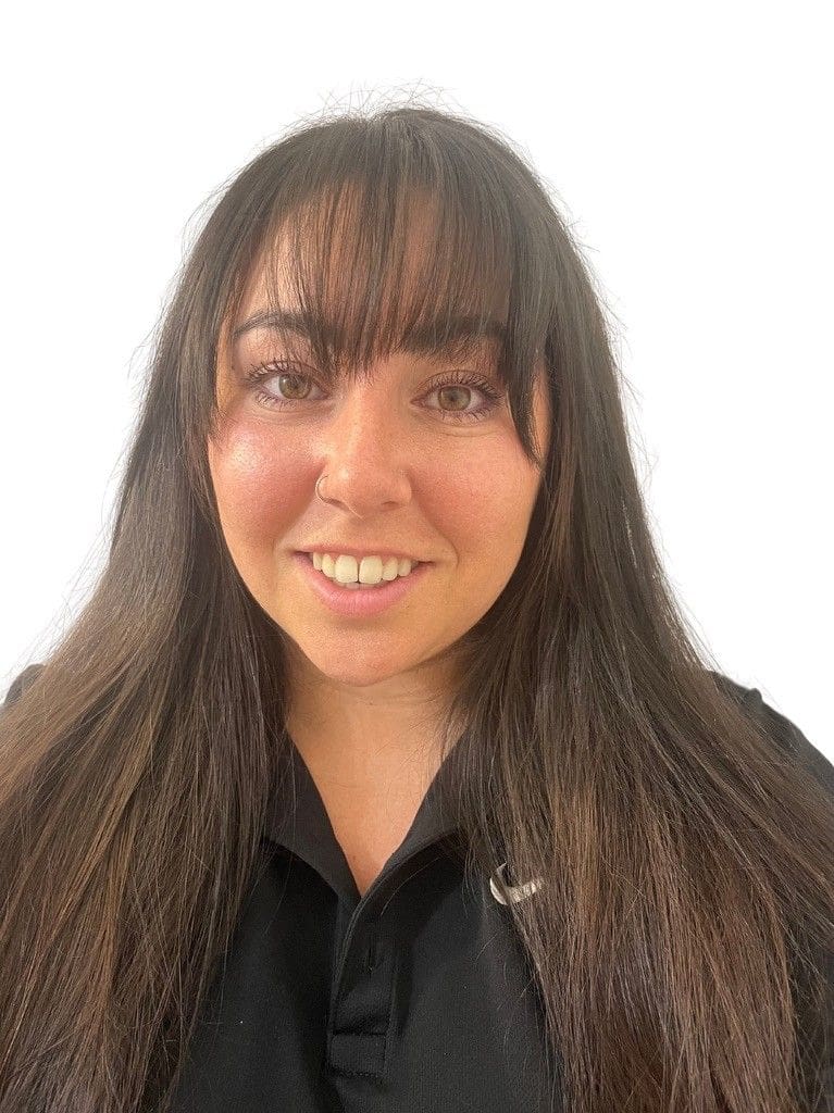 Here's a short alt tag for the image: Smiling woman with long brown hair.