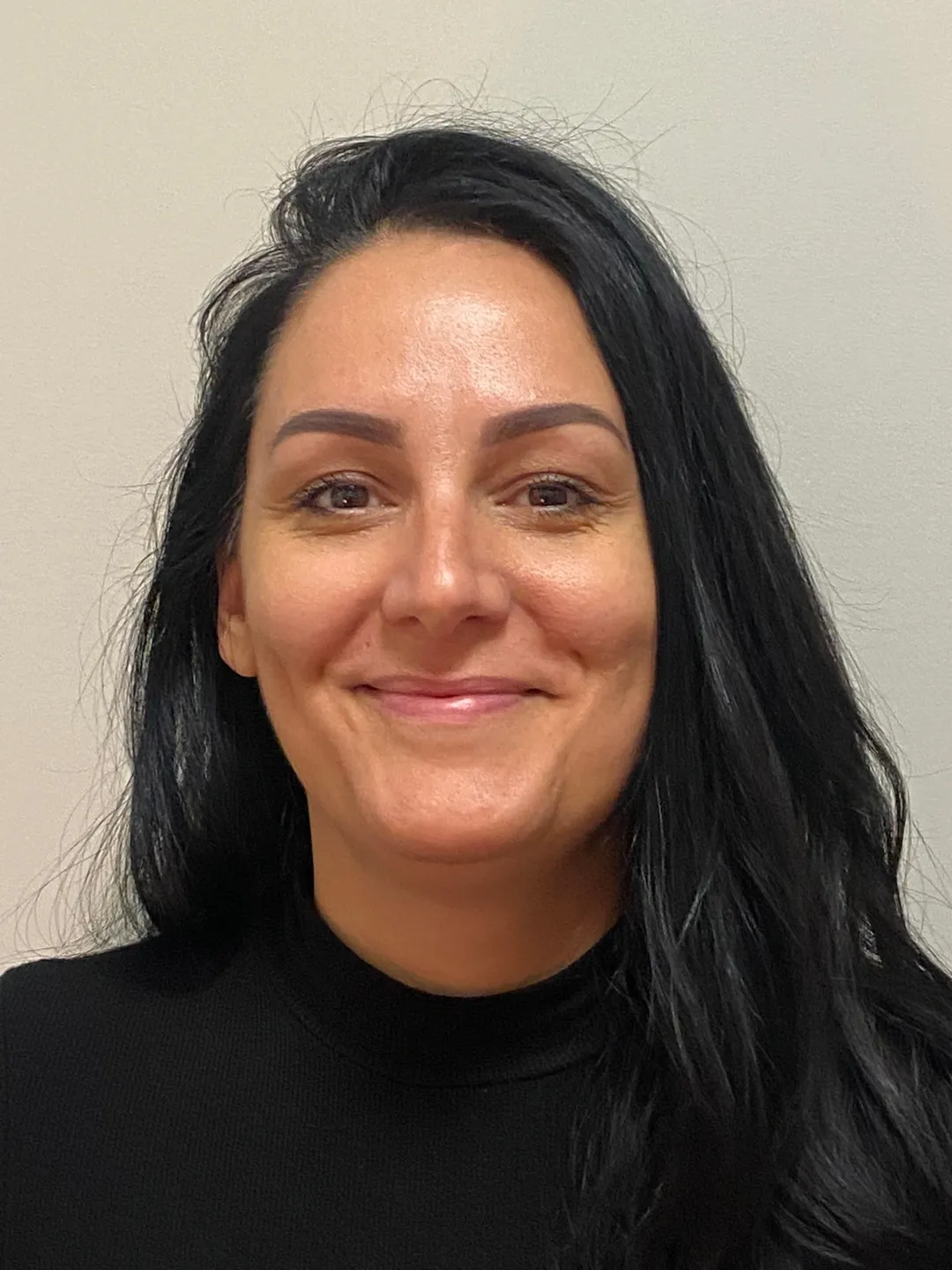 Woman with long black hair, smiling.