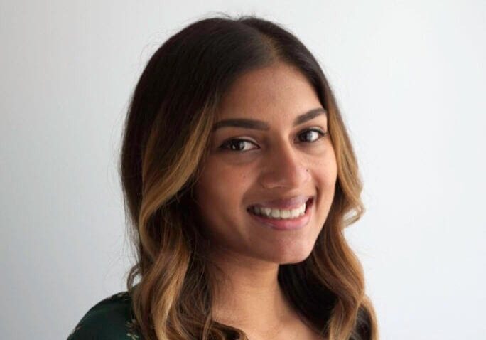 Smiling woman in floral dress.