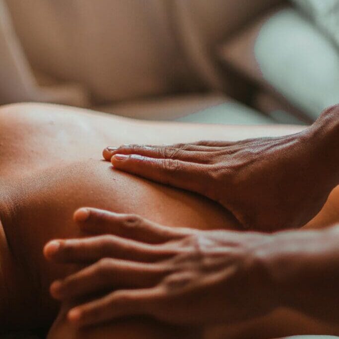 Massage therapy hands on a person's back.