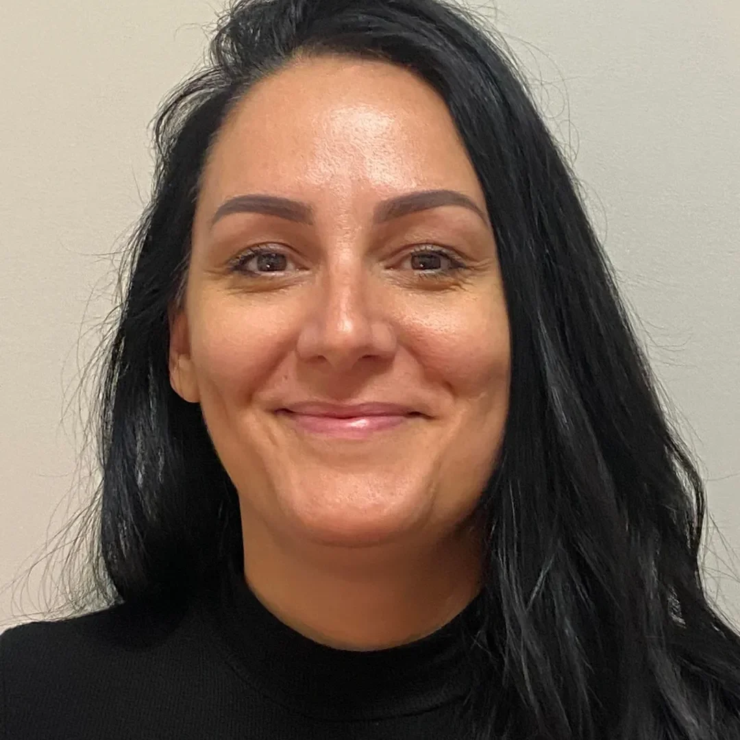 Woman with long black hair, smiling.